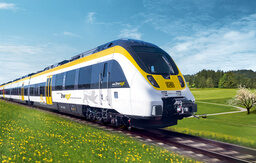 Ein modernder Zug der Deutschen Bahn fährt durch die sommerliche Landschaft Baden-Württembergs