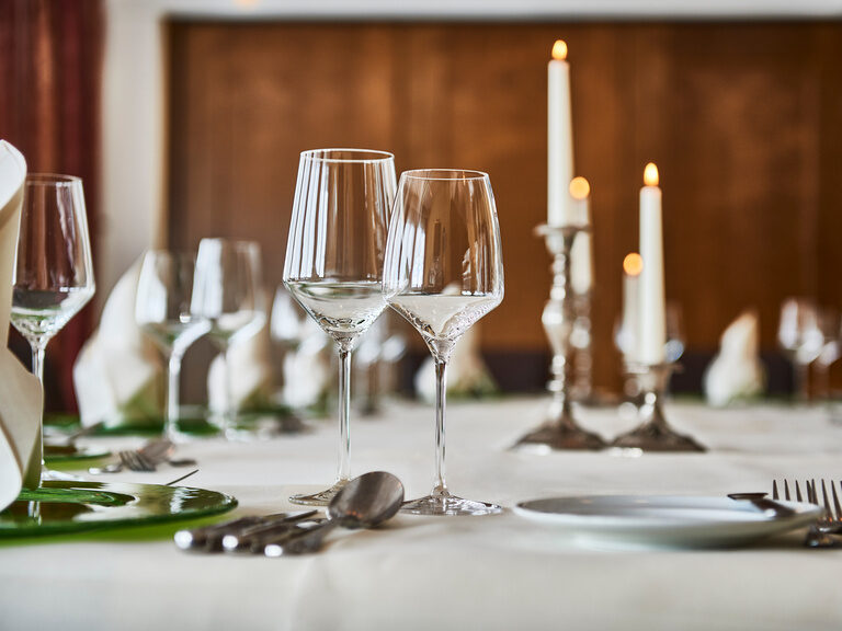 Festively decorated table with cutlery, glasses and napkins.