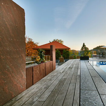 Außenbereich des Wellnessbereichs mit Außenpool, Hochsitzsauna, Liegewiese und Panoramablick in den Schwarzwald.