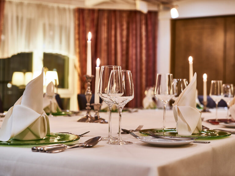 Das Hotelrestaurant Kronelamm bietet den perfekten Rahmen für Feierlichkeiten mit Eleganz. Eine festlich eingedeckte Tafel in Dunkelheit bei Kerzenschein.