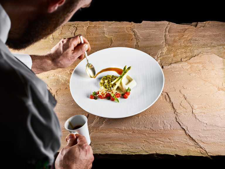 plate is prepared with dessert by a chef.