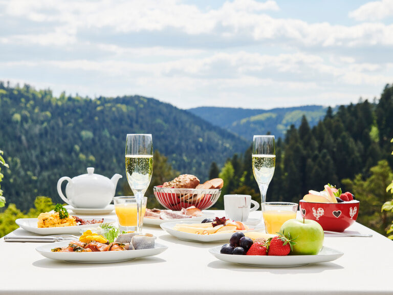 Das Zavelsteiner Schlemmer-Vitalfrühstücksbuffet für den perfekten Start in den Urlaubstag. Leckere Frühstücksspezialitäten stehen auf einem Tisch auf der Panoramaterrasse des Hotelrestaurants Kronelamm im Schwarzwald.