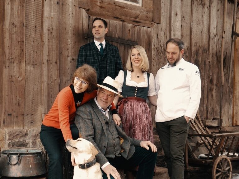 Gudrun, Rolf, Elisabeth, Roland, Franz Berlin and the dog Prinz in front of a hut.