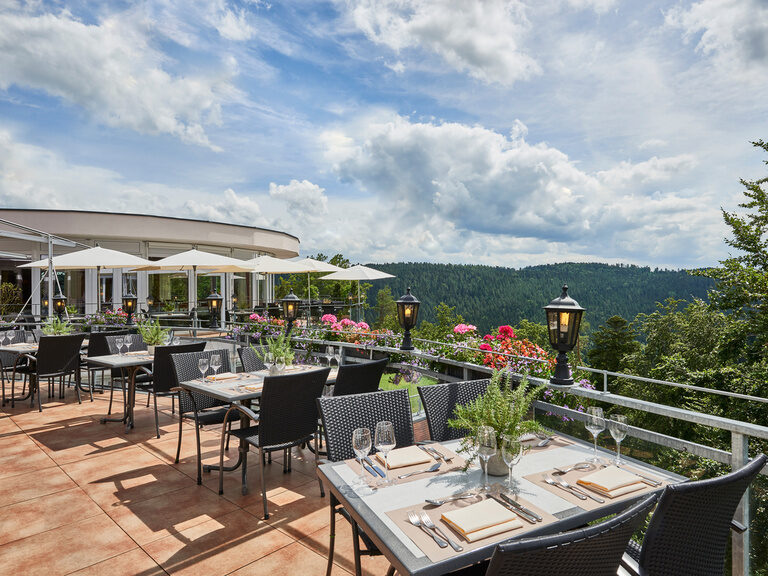 Die Panoramaterrasse des Hotelrestaurants Kronelamm im Schwarzwald bietet Platz für bis zu 80 Personen. Eingedeckte Tische auf einer Terrasse mit Blick in den Schwarzwald.