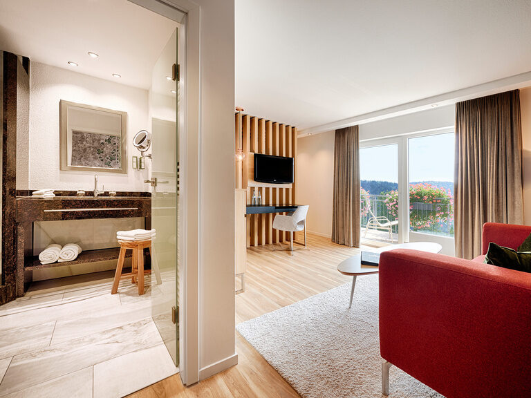Die geschmackvolle Juniorsuite Teinachtal mit Couch, Schreibtisch, fantastischem Ausblick und Marmorbadezimmer.
