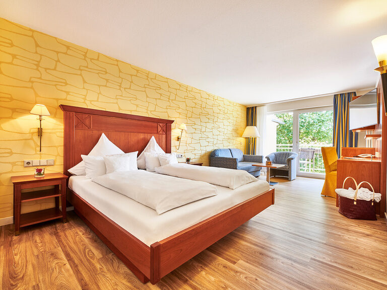 Das, mit Holzboden ausgestattete, Zimmer dieser Kategorie ist mit 42 m² nahezu doppelt so groß. Das große Doppelbett im Klassik Zimmer Typ Zavelstein mit schickem Mobiliar im Hotel Kronelamm.