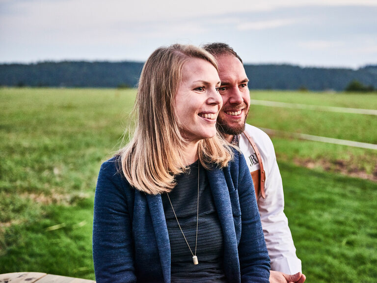 Franz Berlin und seine Schweister Elisabeth Röber-Berlin stehen gemeinsam auf einer Wiese und schauen in die Ferne.