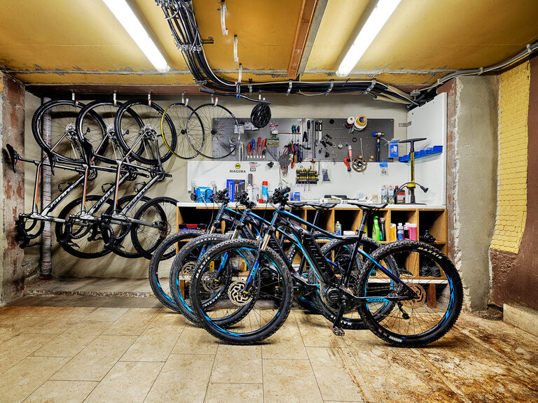 In einem Raum stehen und hängen viele verschiedene Fahrrad-, E-Bike- und Mountainbikemodelle.