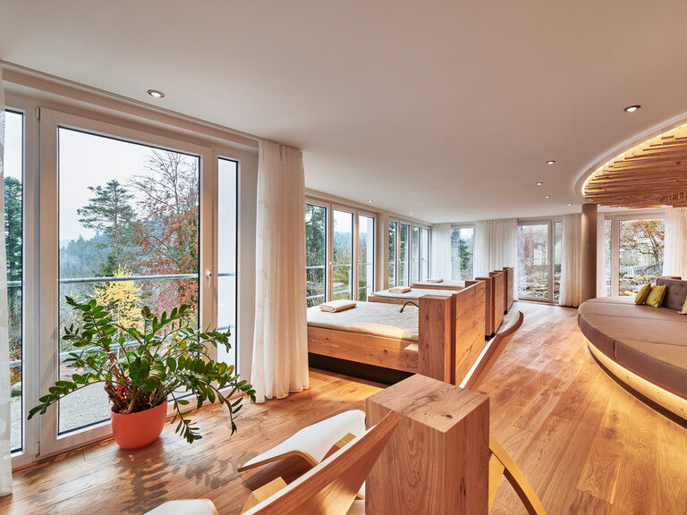 Water beds, loungers and a large lying area in a room with large panoramic windows and a view of the Black Forest.