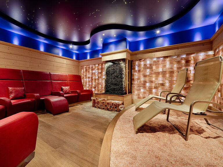 Vor einer Wand aus Salzsteinen befinden sich unterschiedliche Sitz- und Liegemöglichkeiten zum Verweilen.