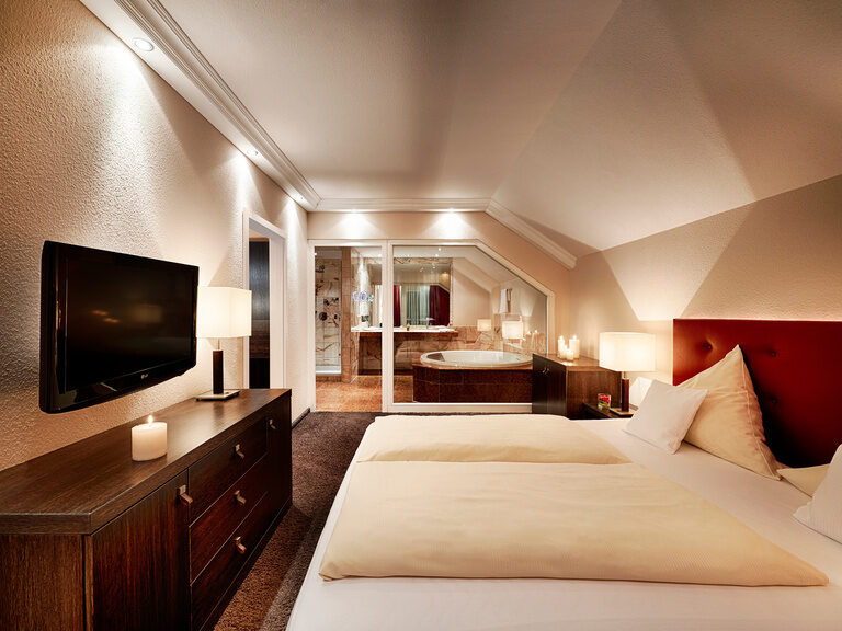 Die exquisit und modern eingerichtete Suite im Haupthaus Hotel Kronelamm eignet sich bestens für besondere Momente zu zweit. Der geräumige Schlafensbereich mit gemachten Betten in der Jungbrunnensuite im Hotel Kronelamm im Schwarzwall