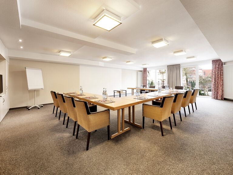 Das Hotel Kronelamm im schwarzwald eignet sich hervorragend für Tagungen und Seminare in Wohlfühlatmosphäre. In einem Raum mit großen Panoramafenstern und Balkon sind Tische und Stühle zu einem U aufgebaut.