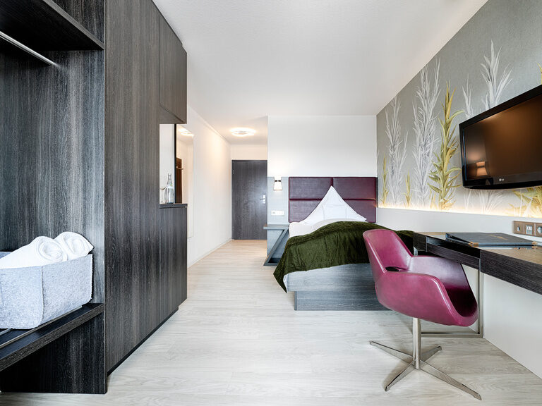 Das moderne Komfort-Einzelzimmer Teinachtal ist zur Südseite gelegen und besticht durch den Ausblick in das Teinachtal. Ein modern eingerichtetes Hotelzimmer mit großem Einzelbett, Kleiderschrank, Schreibtisch und Sessel.