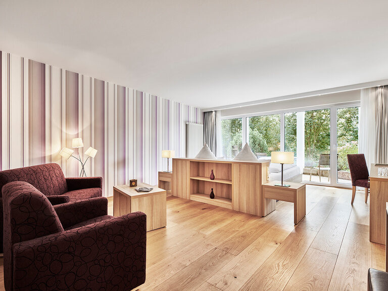 Das helle Wohnzimmer in der Juniorsuite Waldnah mit edlen Möbeln im Hotel Kronelamm im Schwarzwald.