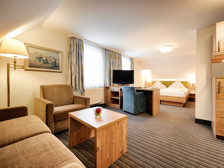 Ein harmonisch eingerichtetes Hotelzimmer mit hochwertigen Möbeln im Landhausstil.