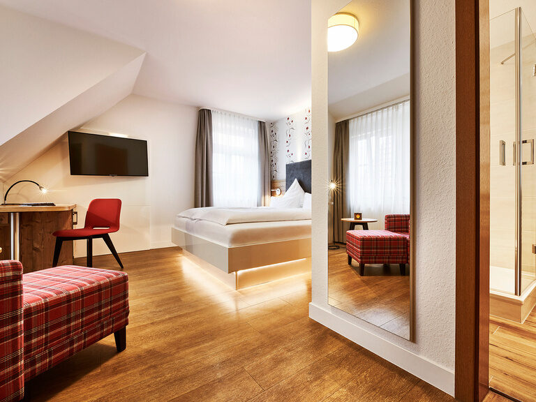 Dieses Zimmer, der Kategorie "Marktbrunnen" befindet sich im Stammhaus Hotel Kronelamm. Ein gemütlich eingerichtetes Hotelzimmer mit großem Bett, Sessel und Schreibtisch.
